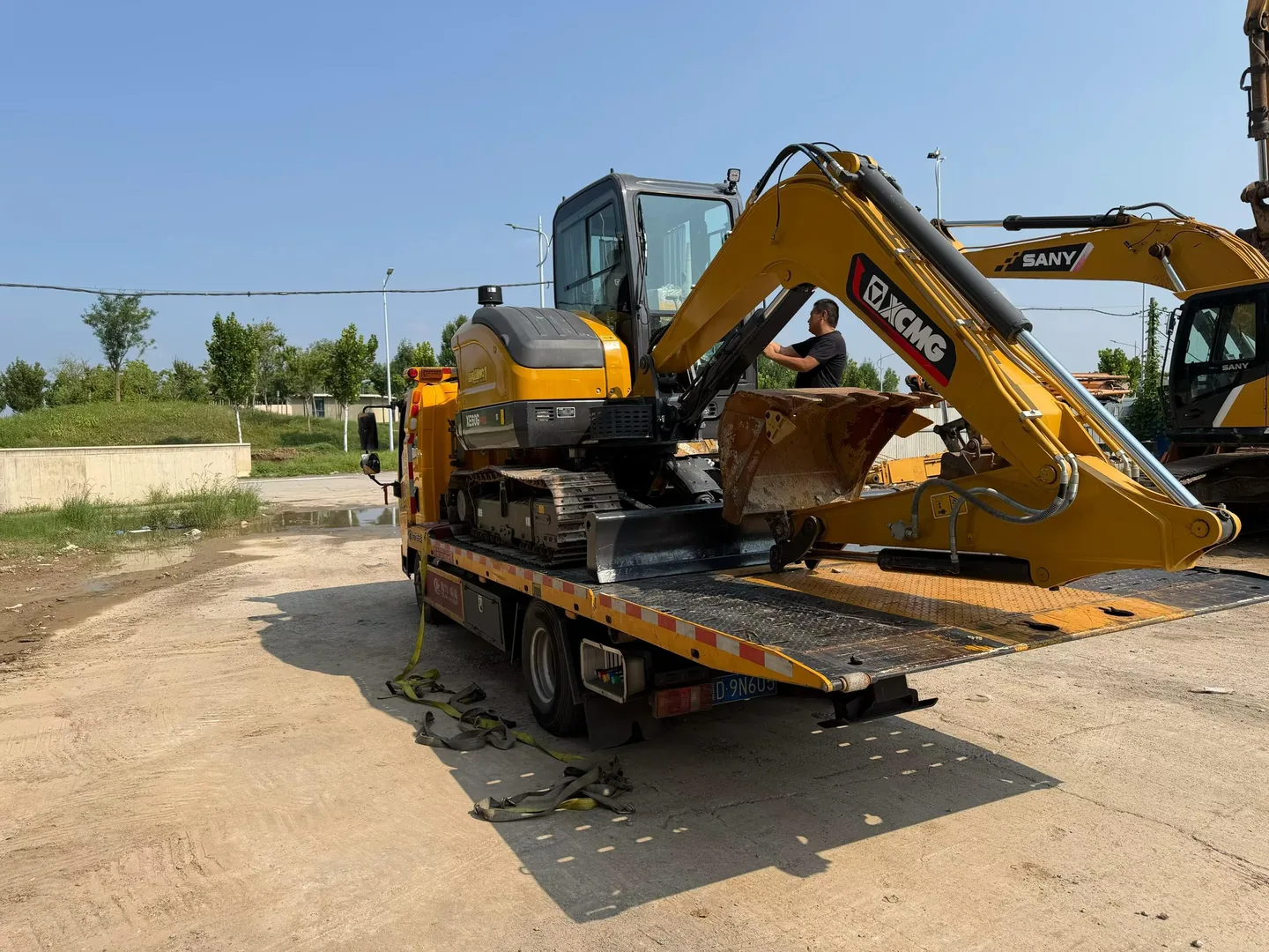 Compact excavators positioned on a transport trailer