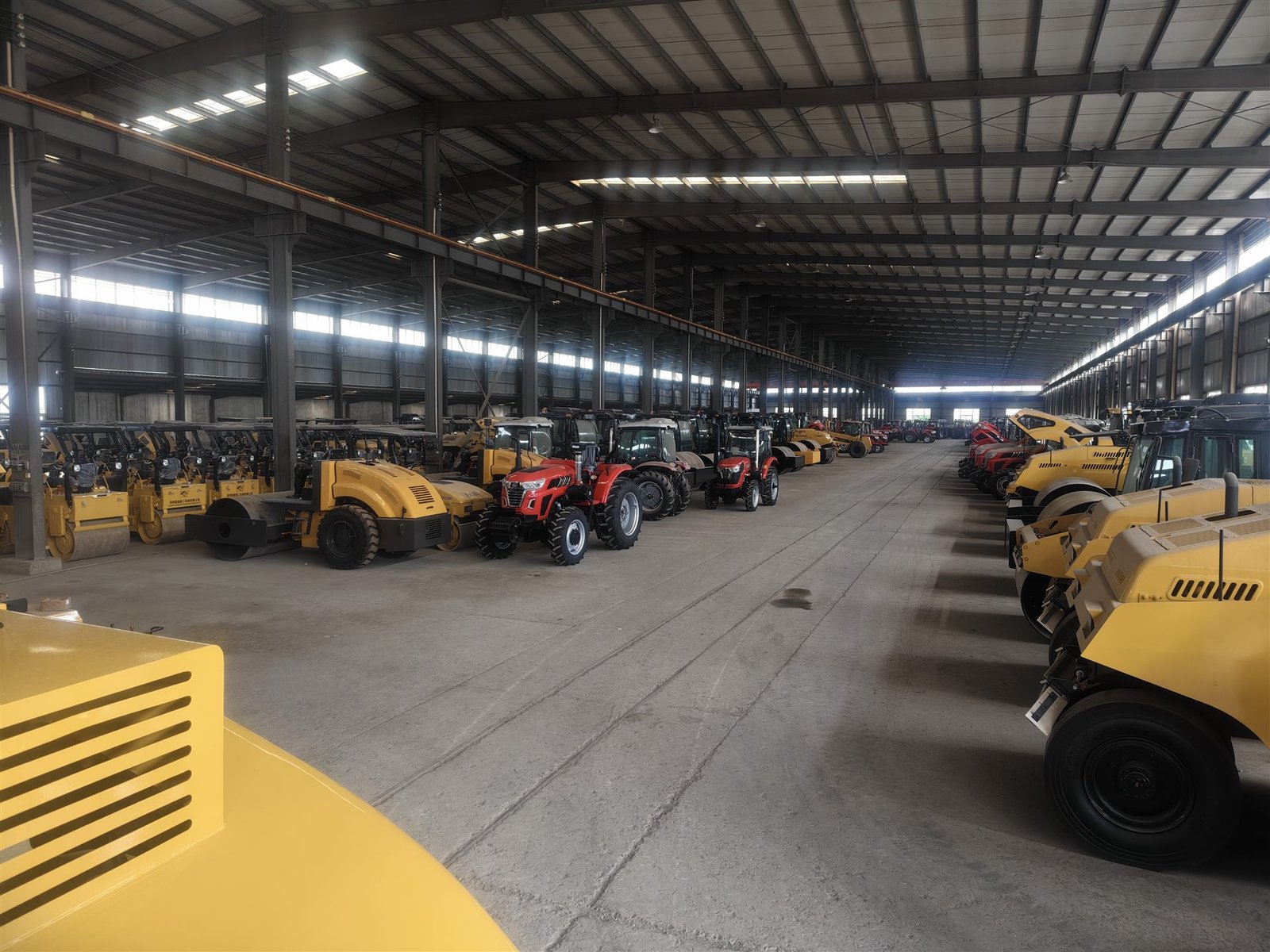 Road rollers and other machinery arranged inside an equipment warehouse
