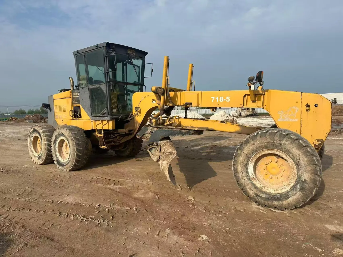 Used motor grader with its blade and wheels visible